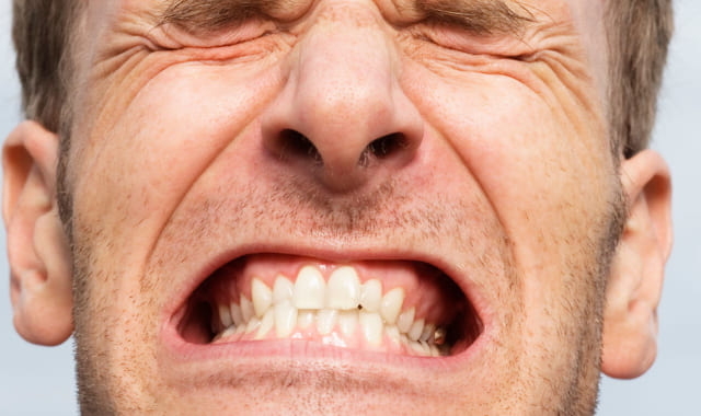 歯を食いしばっている男性