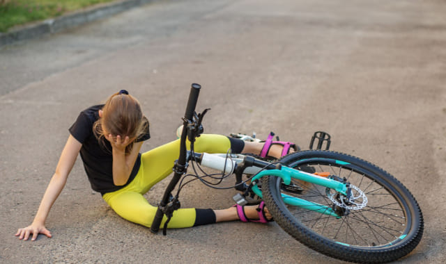 自転車から落ちて転んでいる女性
